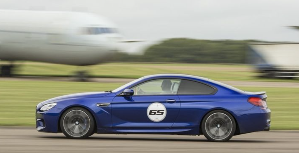 A blue BMW M6 coupe captured at speed on a track.